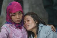 Relatives of victims grieve outside the Adam Malik Hospital following the Indonesian Air Force C-130 Hercules aircraft crash in Medan on June 30, 2015