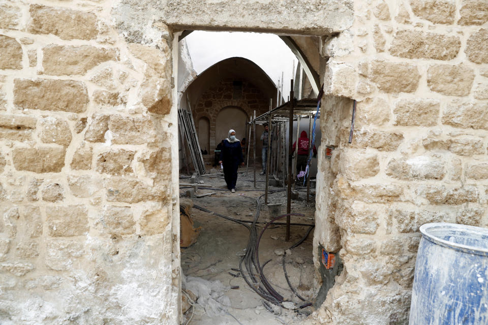 An architect, center, and workers renovate the long-abandoned 200-year-old Ghussein palace, in the old quarter of Gaza City, Monday, Dec. 14, 2020. Less than 200 of these old houses are still partly or entirely standing, according to officials and they are threatened by neglect, decaying and urban sprawl. (AP Photo/Adel Hana)