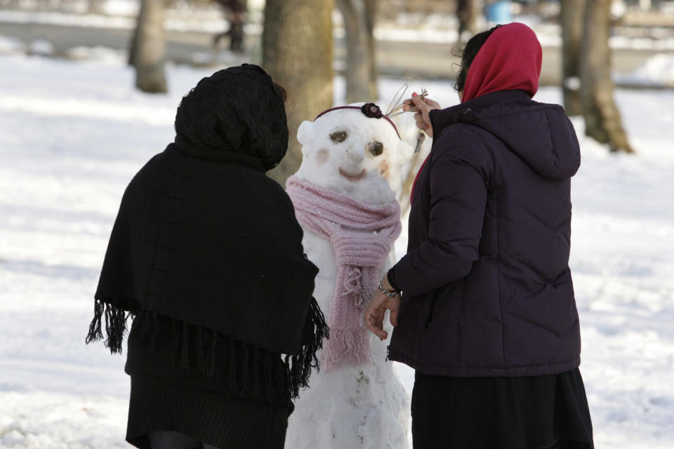 Women build a snowman in Tehran, Iran, on Jan. 21, 2012.