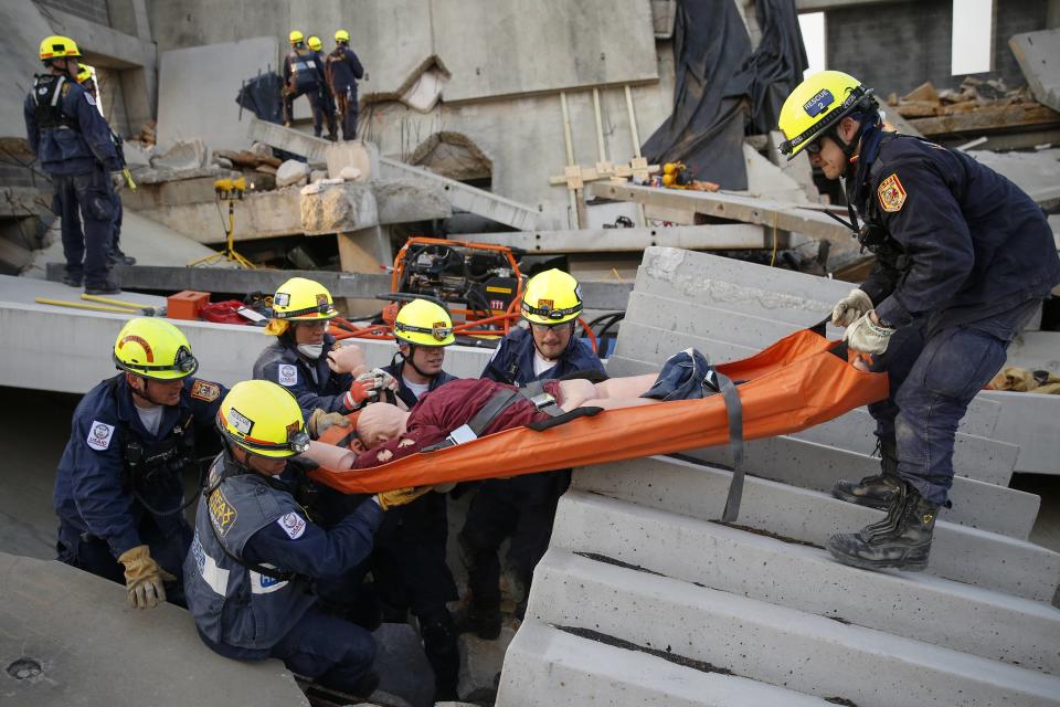 Rescue specialists for USA-1 carry a victim rescued from the scene of a mock disaster area during a training exercise at the Guardian Center in Perry, Georgia, March 25, 2014. (REUTERS/Shannon Stapleton)