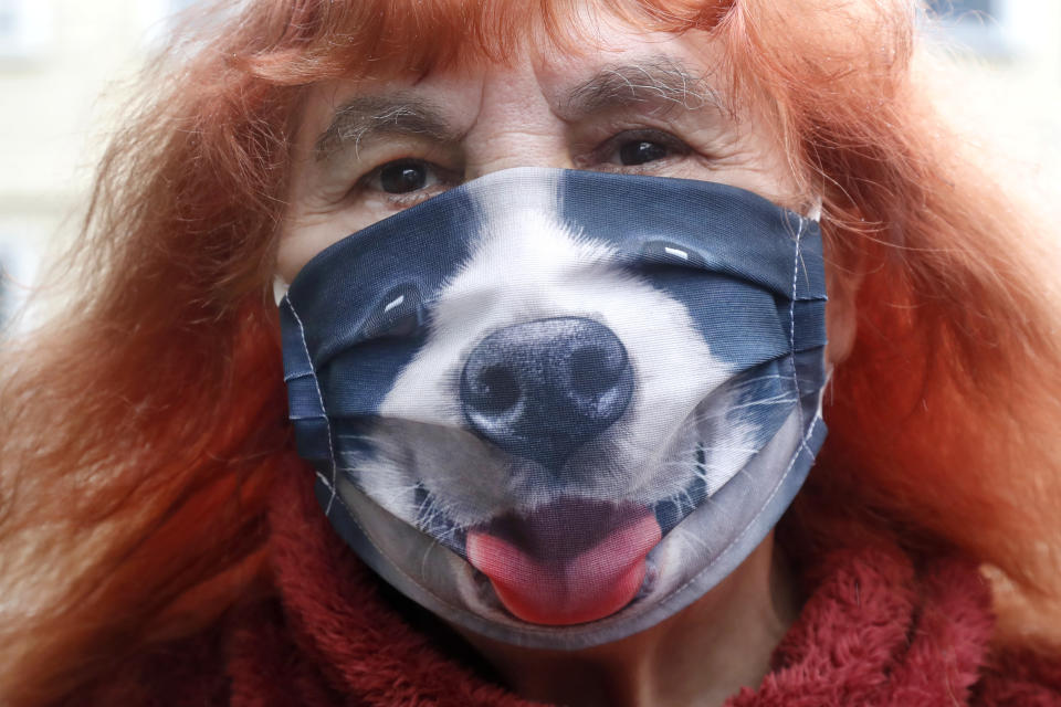 Mimi Taylor wears a doggie mask due to coronavirus concerns as she walks, Tuesday, June 30, 2020, in Cambridge, Mass. (AP Photo/Elise Amendola)