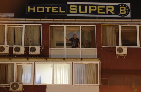 People look from the window of a quarantined hotel in Skopje October 9, 2014. REUTERS/Ognen Teofilovski