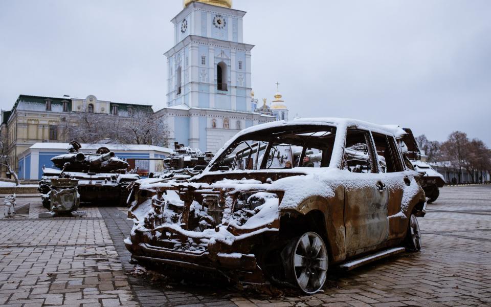 Destroyed vehicles are covered in snow in front of a monastery - Andre Luis Alves/Anadolu Agency