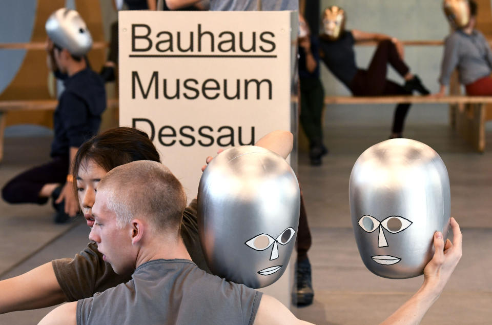 Artists with masks perform prior to the official opening of the new Bauhaus Museum, built for the centenary of the founding of the Bauhaus, in Dessau, Germany Sunday, Sept. 8, 2019. (AP Photo/Jens Meyer)