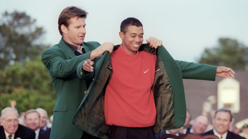 Faldo helps 1997 Masters champion Woods into his green jacket. - TIMOTHY A. CLARY/AFP/AFP via Getty Images