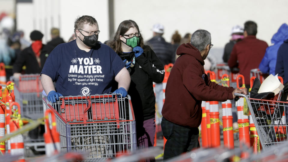 People wear masks as they wait in line at Costco Saturday, April 4, 2020, in Salt Lake City. The Centers for Disease Control and Prevention is now advising Americans to voluntarily wear a basic cloth or fabric face mask to help curb the spread of the new coronavirus. (AP Photo/Rick Bowmer)