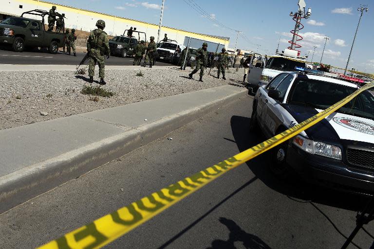 Military police keep guard at the site of a murder on March 24, 2010 in Juarez, Mexico