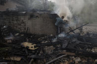 A man tries to extinguish a fire following a Russian bombardment at a residential neighborhood in Kharkiv, Ukraine, Tuesday, April 19, 2022. (AP Photo/Felipe Dana)