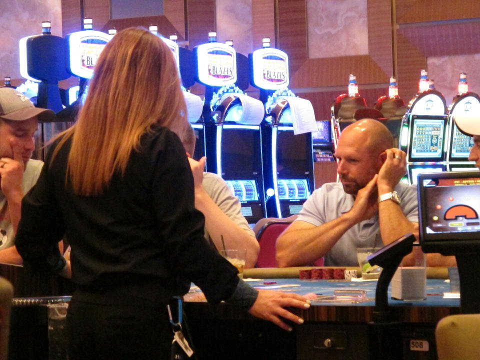 This June 20, 2019 photo shows a gambler playing cards at the Hard Rock casino in Atlantic City N.J. Extra money from sports betting helped New Jersey's casinos and racetracks win nearly $284 million in June, up 21.5 percent from a year ago. (AP Photo/Wayne Parry)