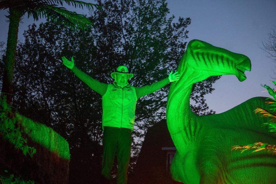 Canterbury Village owner Keith Aldridge poses with the Dinos After Dark animatronics display at the Canterbury Village in Lake Orion on May 27, 2021.