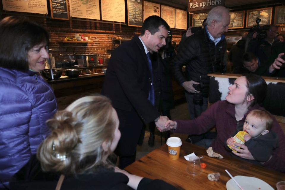 Democratic presidential candidate and former South Bend Mayor Pete Buttigieg, center, shakes hands with guests while visiting a coffee shop with U.S. Rep. Annie Kuster, D-N.H., during a campaign stop in Concord, N.H., Friday, Jan. 17, 2020. (AP Photo/Charles Krupa)