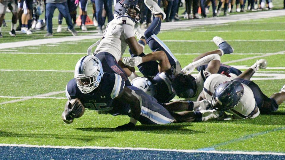 Keiser's Marques Burgess reaches the ball forward as he drives toward the goal-line in the second quarter of Saturday's 38-15 win over visiting St. Thomas on Senior Night.