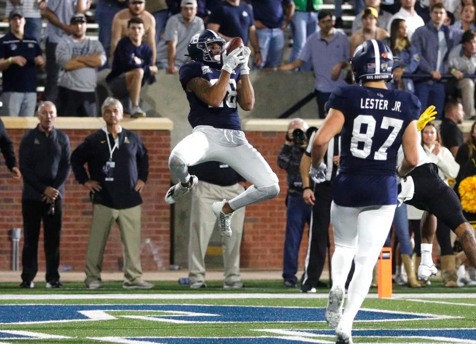 Georgia Southern receiver Ezrah Archie (28) hauls in the game-winning 25-yard touchdown catch in the second overtime during Saturday's game against Appalachian State at Paulson Stadium. Tight end Evan Lester (87) runs to his teammate moments before the celebration began for Eagles fans.