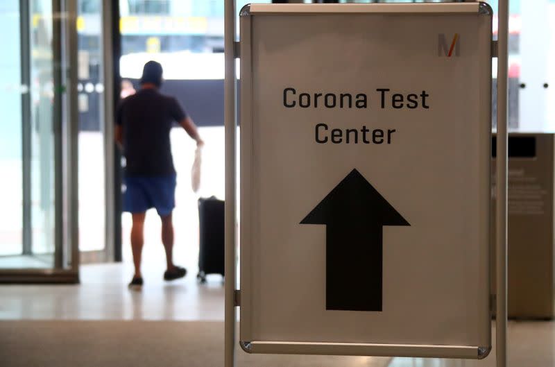 A passenger passes a sign leading to a test center for the coronavirus disease (COVID-19), at Munich International Airport