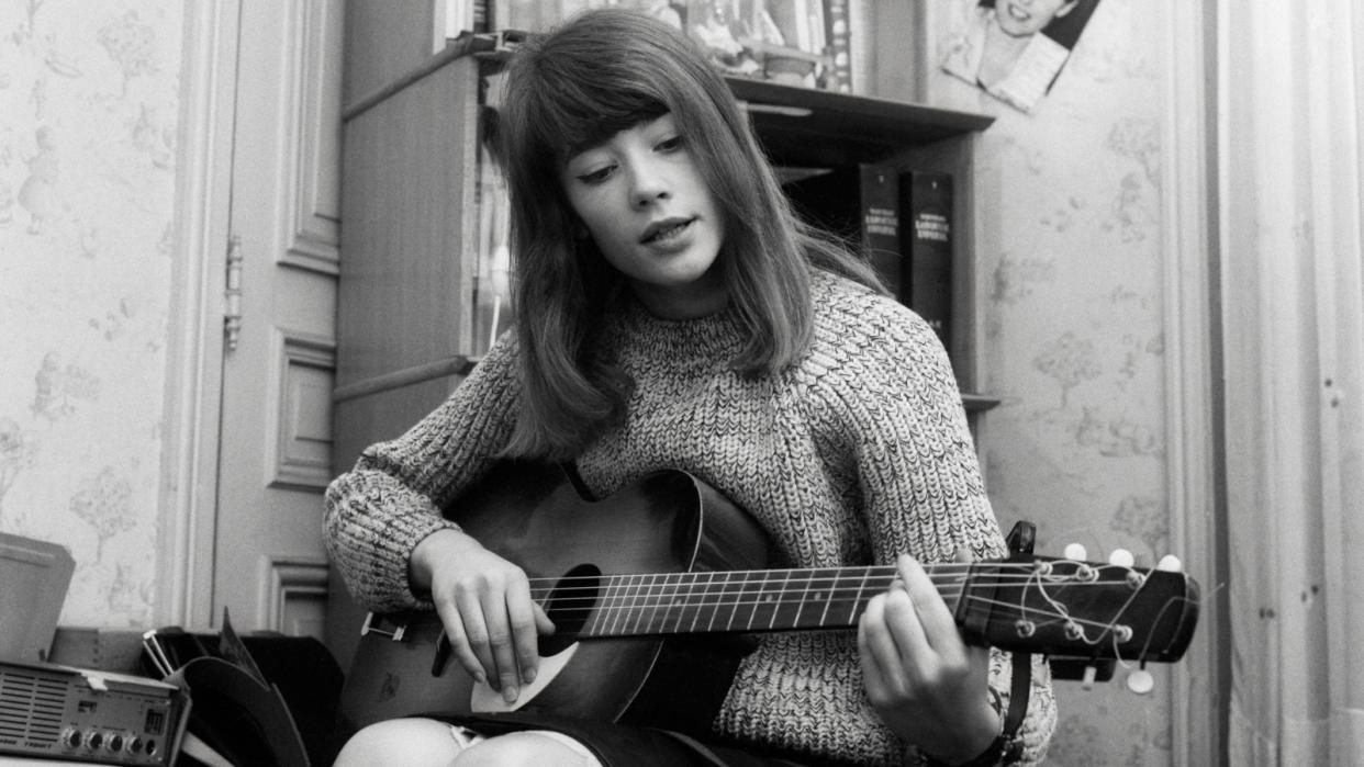  Francoise Hardy plays an acoustic guitar. Hardy, very popular in France, is known for writing many of her own songs.  