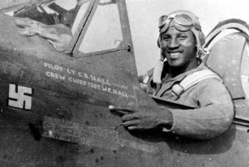 On July 2, 1943, Lt. Charles Hall became the first African-American pilot to shoot down a Nazi plane in World War II during an Allied assault on three Italian air bases. Seated in his P-40L Warhawk, Hall points to a freshly painted swastika marking his kill. File Photo courtesy of the U.S. Air Force