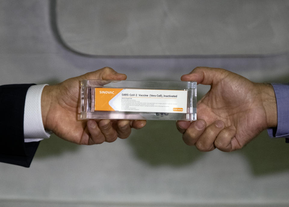 Sao Paulo Governor Joao Doria, left, and Butantan Institute Director Dimas Covas show a box of an experimental COVID-19 vaccine that is being tested in partnership with China's pharmaceutical company Sinovac during a press conference in Sao Paulo, Brazil, Monday, Nov. 9, 2020. (AP Photo/Andre Penner)