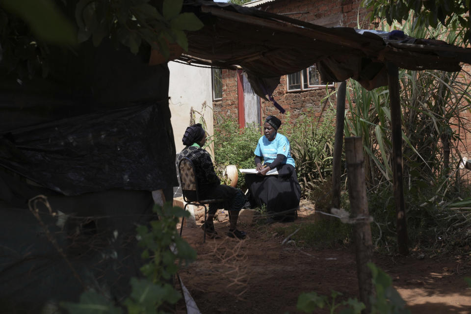 Siridzayi Dzukwa, a grandmother, right, talks to Tambudzai Tembo outside her house in Hatfcliffe on the outskirts of the capital Harare, Zimbabwe, Wednesday, May 15, 2024. In Zimbabwe, talk therapy involving park benches and a network of grandmothers has become a saving grace for people with mental health issues. Now the concept is being adopted in parts of the United States and elsewhere. (AP Photo/Tsvangirayi Mukwazhi)
