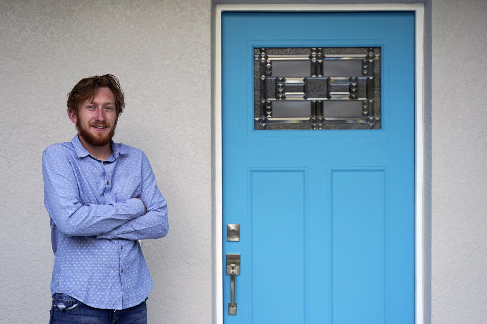 First-time buyer Kevin Muglach stands in front of his new home, Tuesday, April 6, 2021, in Orange City, Fla. Homebuyers are facing the most competitive U.S. housing market in decades this spring, as surging prices and a record-low number of homes for sale narrow the already difficult path to home ownership for many Americans. (AP Photo/John Raoux)