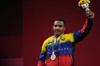Julio Ruben Mayora Pernia of Venezuela celebrates on the podium after winning the silver medal in the men's 73kg weightlifting event, at the 2020 Summer Olympics, Wednesday, July 28, 2021, in Tokyo, Japan. (AP Photo/Luca Bruno)