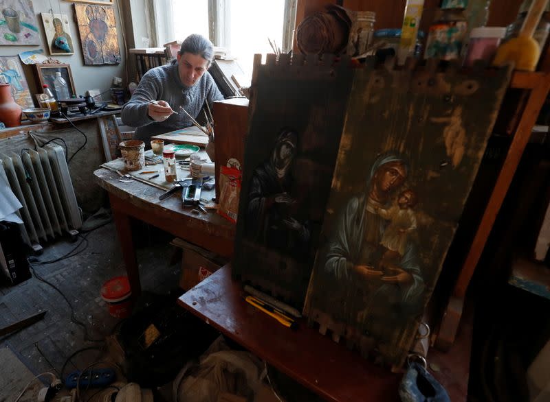 Ukrainian artist Oleksandr Klymenko works on an icon at a studio in Kyiv