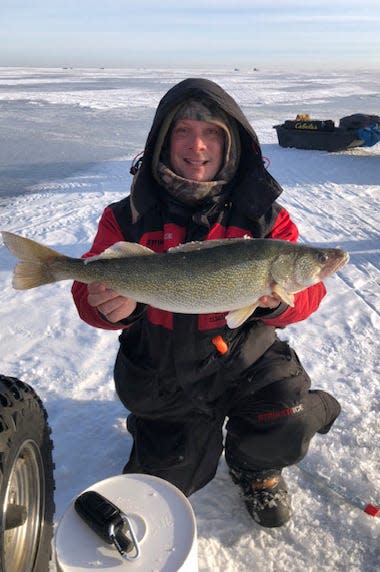 Brian Seiferlein poses for a photo with a walleye while fishing on Saginaw Bay.