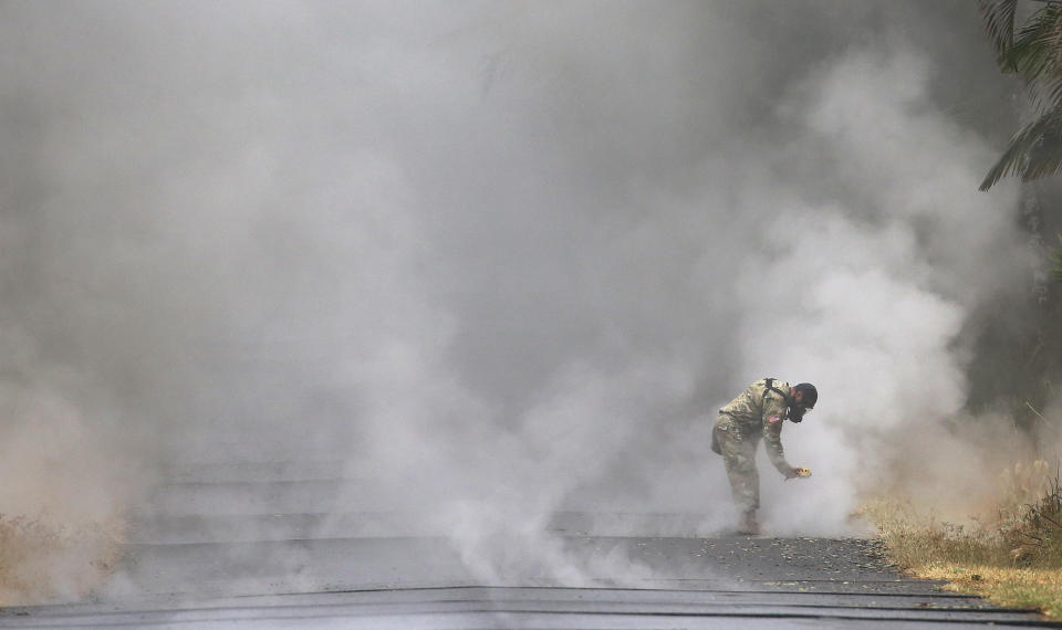 U.S. Army National Guard&nbsp;1st Lt. Aaron Hew Len takes measurements for sulfur dioxide gas at volcanic fissures in Leilani Estates on Tuesday.