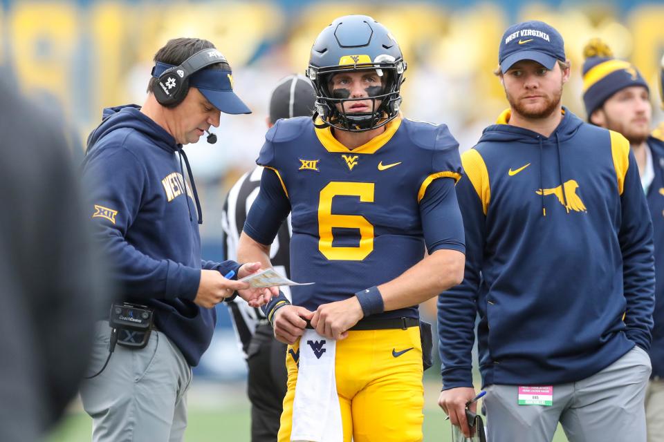 West Virginia coach Neal Brown talks with quarterback Garrett Greene (6) during the first quarter against OSU on Oct. 21 in Morgantown, W.Va.