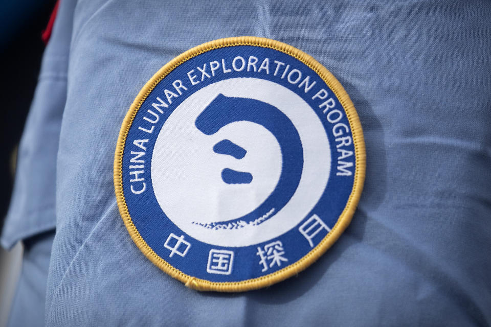 A patch for the China Lunar Exploration Program is displayed on the uniform of a worker at the Wenchang Space Launch Site in Wenchang in southern China's Hainan province, Monday, Nov. 23, 2020. Chinese technicians were making final preparations Monday for a mission to bring back material from the moon's surface for the first time in nearly half a century — an undertaking that could boost human understanding of the moon and of the solar system more generally. (AP Photo/Mark Schiefelbein)