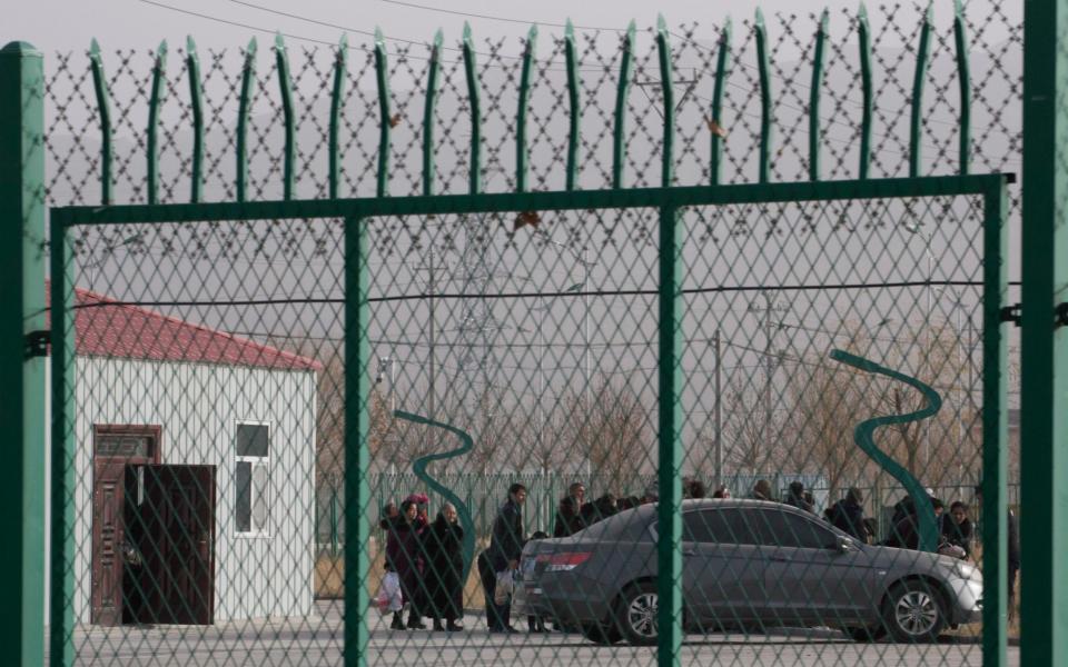 People line up at a 'vocational skills centre' in China's Xinjiang - AP Photo/Ng Han Guan, File