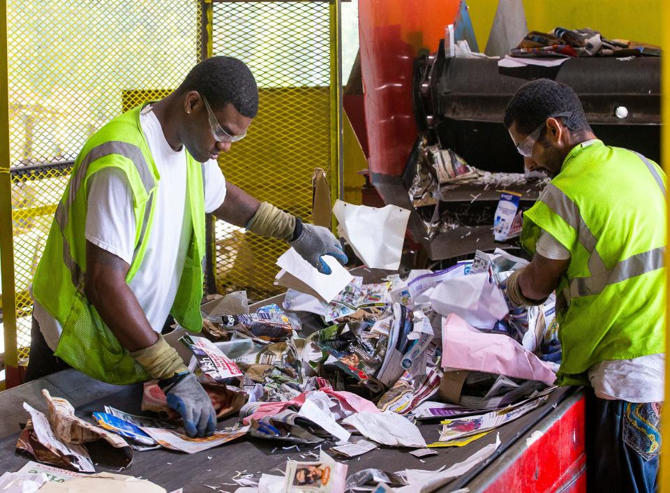 Quality control workers with material recovery facility work on separating recyclable items at the Leveda Brown Environmental Park and Transfer Station in 2019.