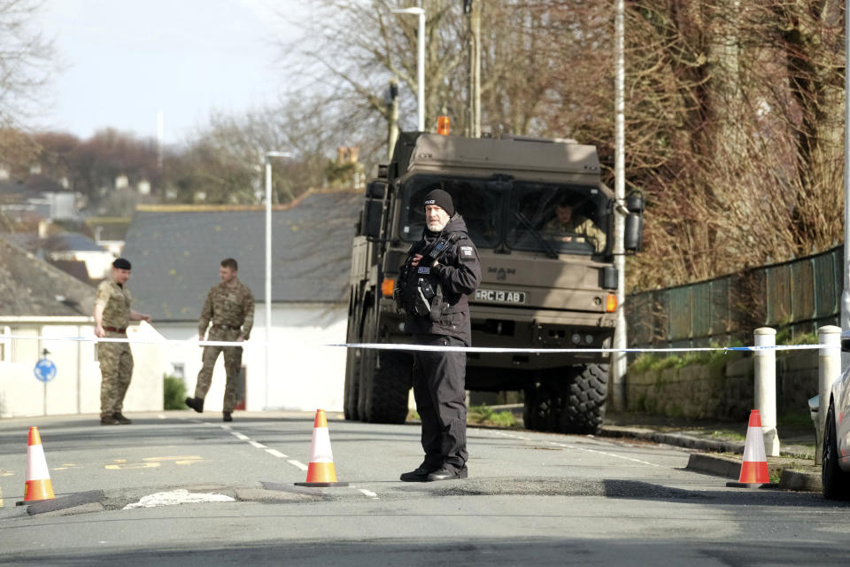 Police and bomb disposal experts stand at the scene near St Michael Avenue, where residents have been evacuated and a cordon put in place following the discovery of a suspected Second World War explosive device, in Plymouth, England, Friday Feb. 23, 2024. (Matt Keeble/PA via AP)