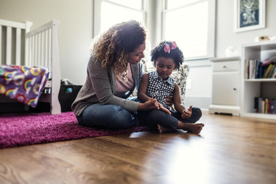 Mother and daughter playing on bedroom floor