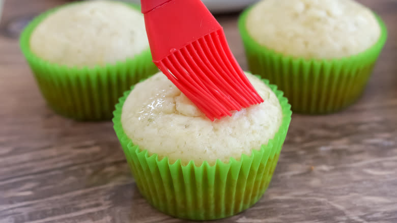 cupcakes being brushed with simple syrup