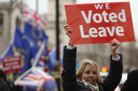 A pro-Brexit demonstrator waves a placard with others outside the Houses of Parliament in London Tuesday, Dec. 18, 2018. The British Cabinet was meeting Tuesday to discuss ramping up preparations for Britain's departure from the European Union without a deal, after Prime Minister Theresa May postponed Parliament's vote on her divorce agreement until mid-January. (AP Photo/Alastair Grant)