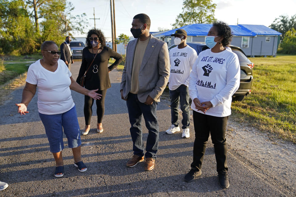 FILE - EPA Administrator Michael Regan, center, talks with Brenda Bryant, left, and other members of the group Rise St. James, as he tours a neighborhood next to the Nu Star Energy oil storage tanks, in St. James Parish, La., Nov. 16, 2021. The Biden administration is granting Louisiana's request to administer its own permit program for wells that store carbon dioxide. It will be just the third state to take over that job from the EPA. The EPA said the Louisiana agreement includes safeguards to protect poorer, often majority-Black communities that live near those facilities. Regan said Thursday, Dec. 28, 2023, "It can be done in a way that builds in environmental justice principles that allow for the community to participate in the process and ensures that these communities are safe." (AP Photo/Gerald Herbert, File)