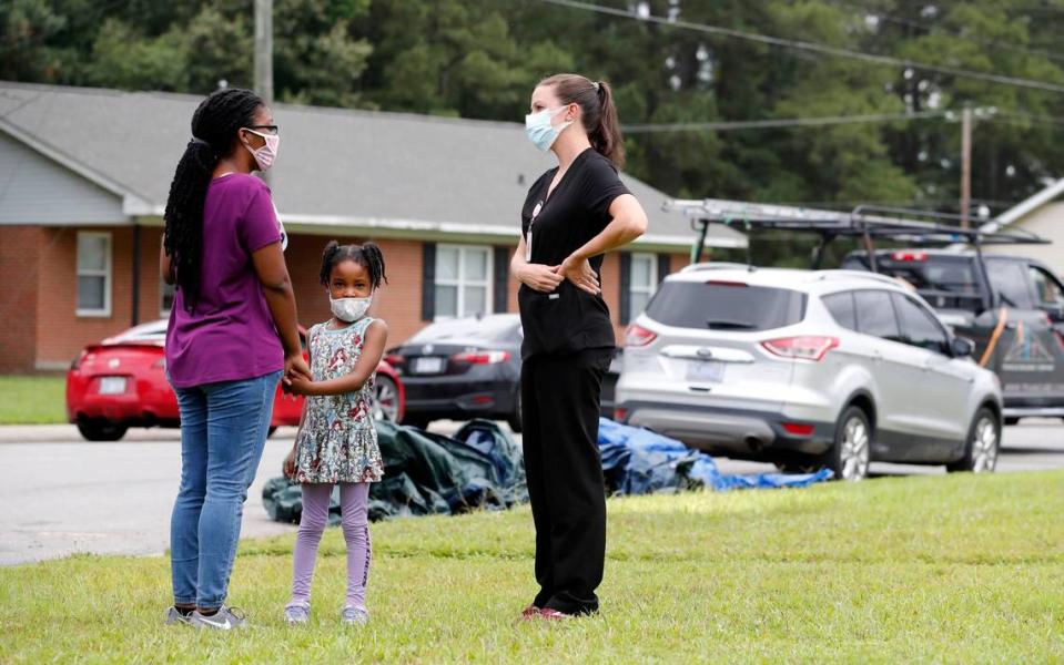 Erin Smith, family nurse practitioner with the Johnston County Public Health Department, talks with Briona Davis after she received a COVID-19 vaccine shot during a pop up vaccine clinic in the Smithfield Housing Authoritys subdivision of Woodall Heights in Smithfield, N.C. Tuesday, June 8, 2021. With Davis is her daughter, Rayona Jones.