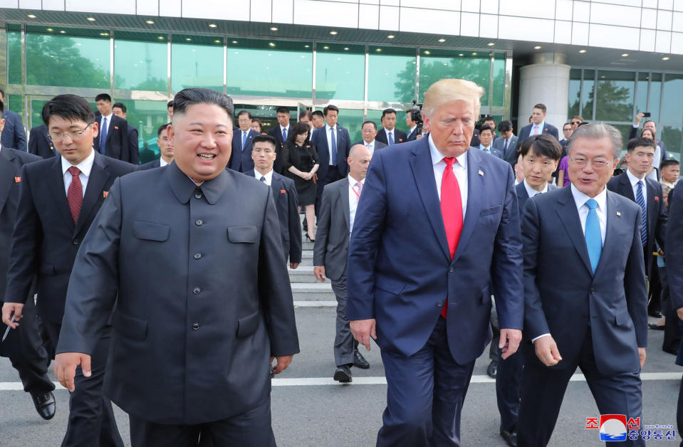 In this Sunday, June 30, 2019, photo provided by the North Korean government, North Korean leader Kim Jong Un, front left, U.S. President Donald Trump, front center, and South Korean President Moon Jae-in, front right, walk together at the border village of Panmunjom in Demilitarized Zone. The content of this image is as provided and cannot be independently verified. Korean language watermark on image as provided by source reads: "KCNA" which is the abbreviation for Korean Central News Agency. (Korean Central News Agency/Korea News Service via AP)