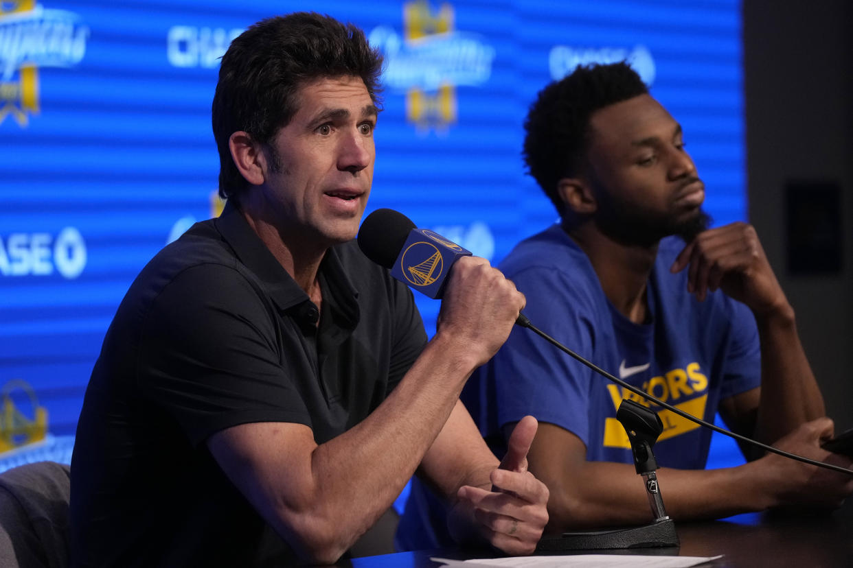 Golden State Warriors general manager Bob Myers speaks next to forward Andrew Wiggins before an NBA basketball game between the Warriors and the Oklahoma City Thunder in San Francisco, Tuesday, April 4, 2023. (AP Photo/Jeff Chiu)