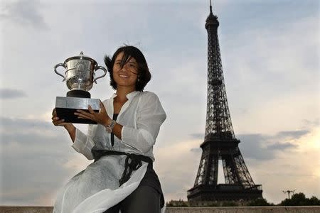 Li Na of China poses with her trophy near the Eiffel Tower in Paris after winning her women's final against Francesca Schiavone of Italy at the French Open tennis tournament at the Roland Garros stadium in Paris June 4, 2011. REUTERS/Charles Platiau