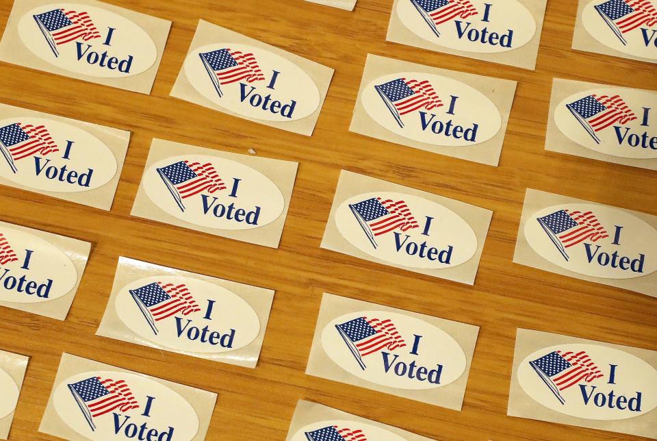 FILE — "I Voted" stickers are spread out on a table next to the ballot drop box for in-person voting at ​the Marvin Williams Recreation Center in Bremerton in November 2020.