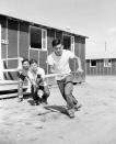 <p>These Japanese-Americans, part of an advanced contingent at the Rohwer Relocation Center near McGehee, Arkansas, Sept. 21, 1942, find time to play baseball. The batter is Tom Kinmotsu, the catcher is his brother, Yosh Kinmotsu, and Al Umino is doing the umpiring. The advanced group will get the camp ready for other West Coast evacuees who will make their home for the duration. (AP Photo/Horace Cort) </p>