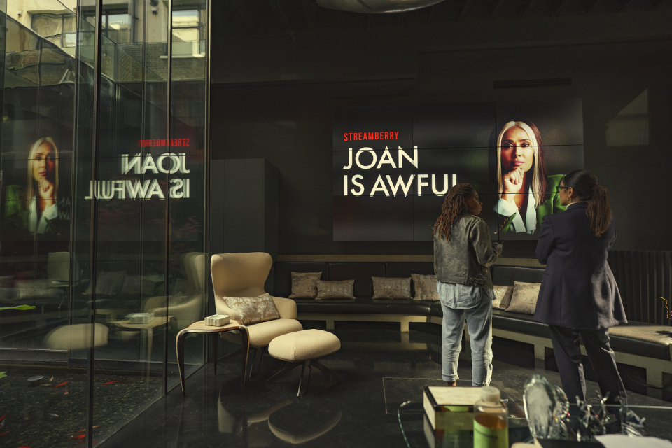 two women staring at a screen that reads 'joan is awful' in black mirror season 6