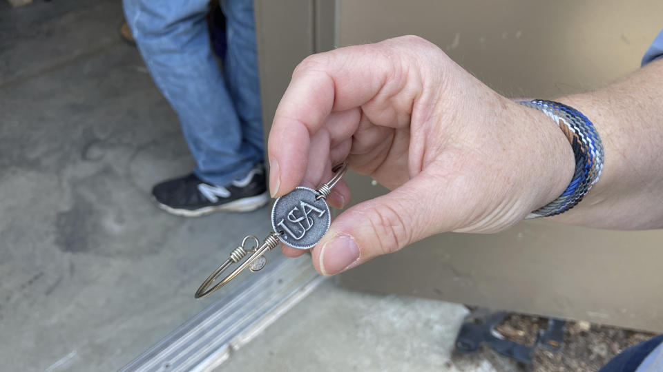 Stacey Ferguson of the Historic Camden Foundation, shows a replica she made of a U.S. soldier's button found among the unidentified remains of a Revolutionary War soldier killed in the Battle of Camden in 1780 on Thursday, March 30, 2023, in Columbia, South Carolina. The remains of 14 soldiers were removed from the battlefield, studied and analyzed and will be buried in a ceremony. (AP Photo/Jeffrey Collins)