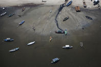 In this Nov. 19, 2013 photo small boats sit on the shore of Guanabara Bay in the suburb of Sao Goncalo, across the bay from Rio de Janeiro, Brazil. Rio dumps almost 70 percent of its untreated sewage into its surrounding waters, which fouls the bay with human waste and floating debris. (AP Photo/Felipe Dana)