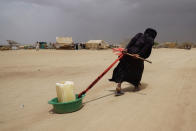 <p>ABS IDP Settlement, ABS Governorate, Yemen, May 4, 2017: A displaced woman drags water back to her tent in Abs IDP camp located just 40 KM from the frontline to Saudi Arabia. (Photograph by Giles Clarke for UN OCHA/Getty Images) </p>