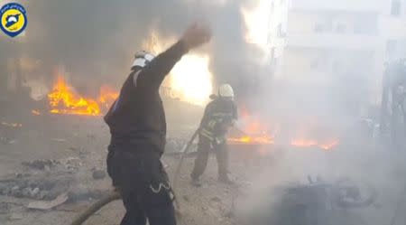 A still image taken from a video uploaded by White Helmets on June 24, 2017, shows civil defence members trying to put out a fire at the site of a car bomb, said to be in the town of al-Dana, in Syria's rebel-held Idlib province. White Helmets via Reuters TV