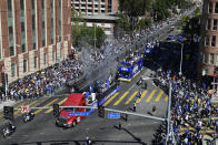 Buses carrying Los Angeles Rams players and coaches drive past fans during the team's victory parade in Los Angeles, Wednesday, Feb. 16, 2022, following their win Sunday over the Cincinnati Bengals in the NFL Super Bowl 56 football game. (AP Photo/Kyusung Gong)