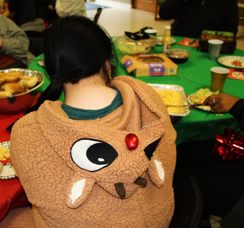 A student sports a Rudolph The Red Nosed Reindeer outfit during Oakland Academy's holiday celebration on Thursday, Dec. 21, 2023. The students raised $300, which they donated to the Community Cancer Network in honor of their front office worker, Gail McCormick, who is battling breast cancer.
