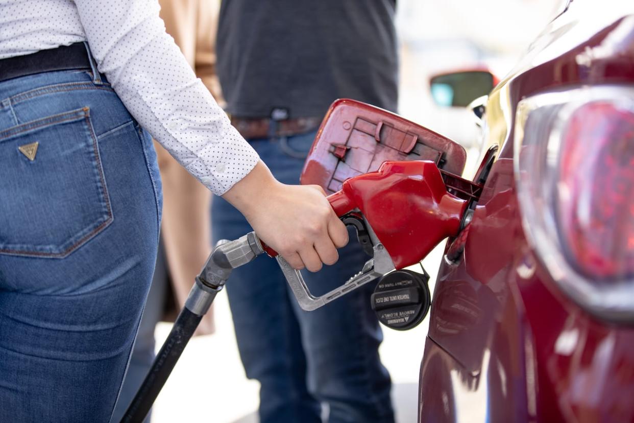 A woman fills up her tank at a Metro Vancouver gas station. (Evan Mitsui/CBC - image credit)